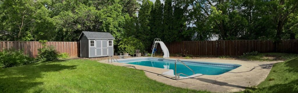 A pool house by Horizon Storage Sheds next to an in-ground pool